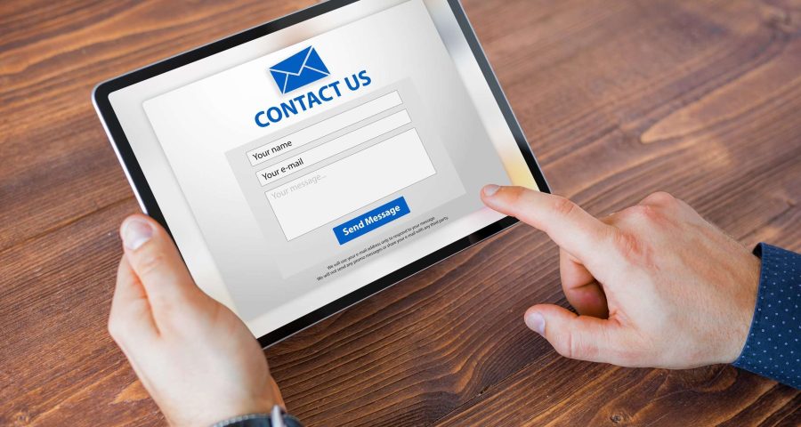 person filling out an online contact form on an ipad